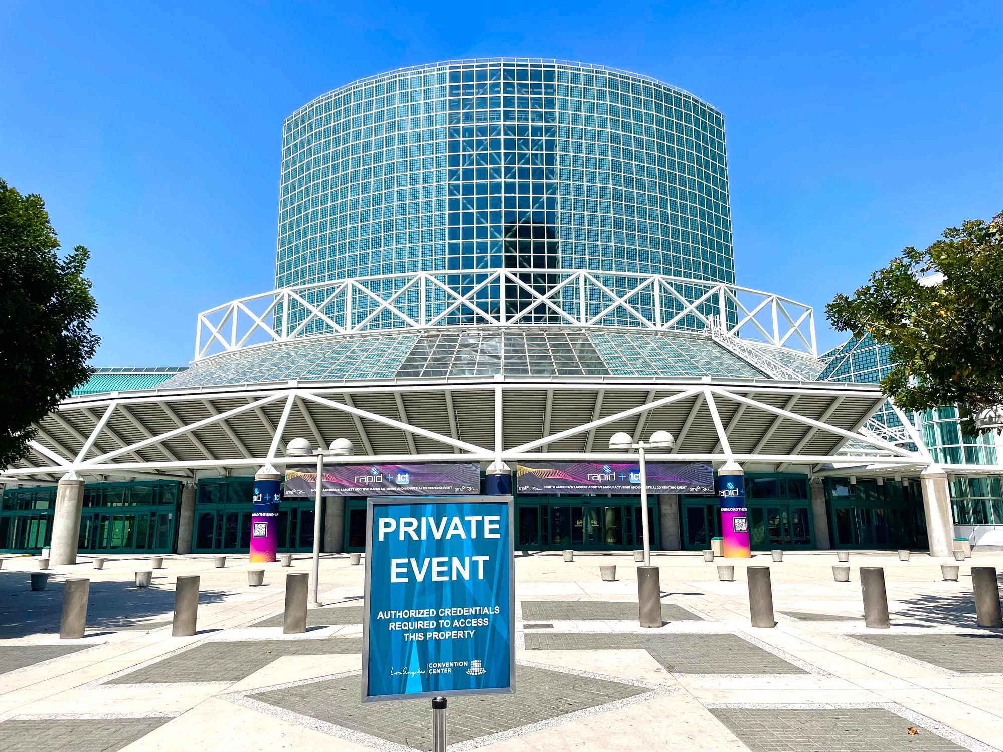 The convention center atrium with tall walls of curved greenish fake glass block and a sign that shows "private event" convention