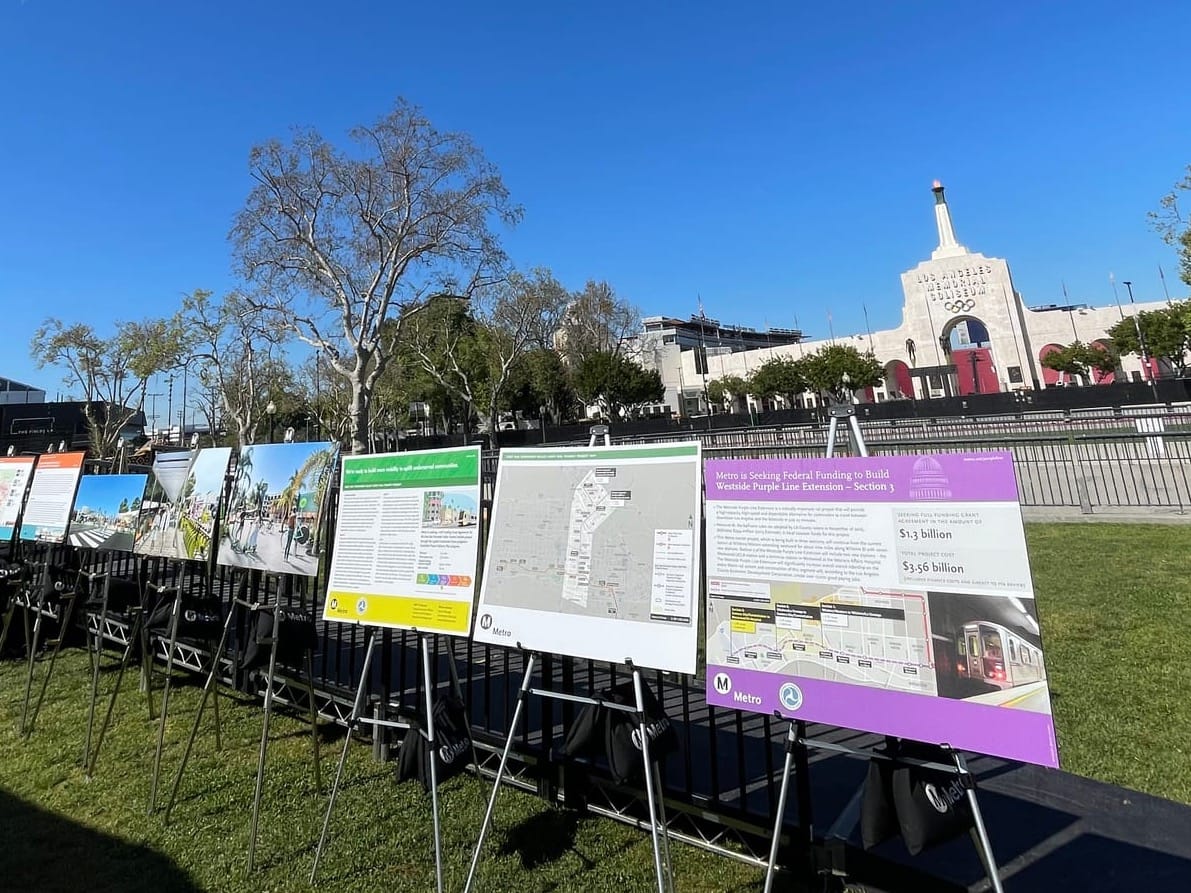 Metro presentation boards on easels in front of the Coliseum showing that Metro is seeking federal funding to finish building the 3rd phase of the D or Purple line