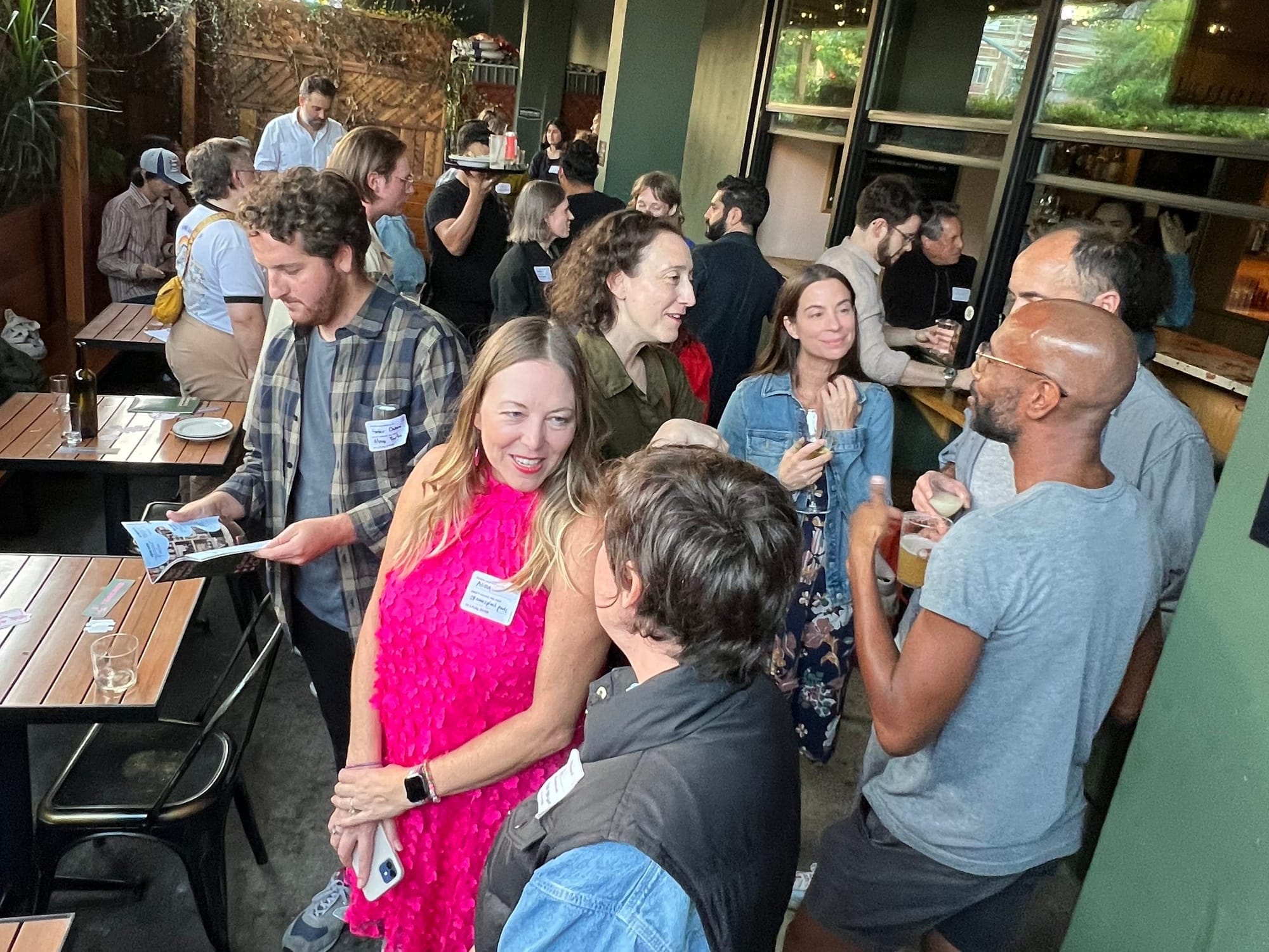 A crowd gathered in a bar for the Torched launch party, chatting and laughing on a patio