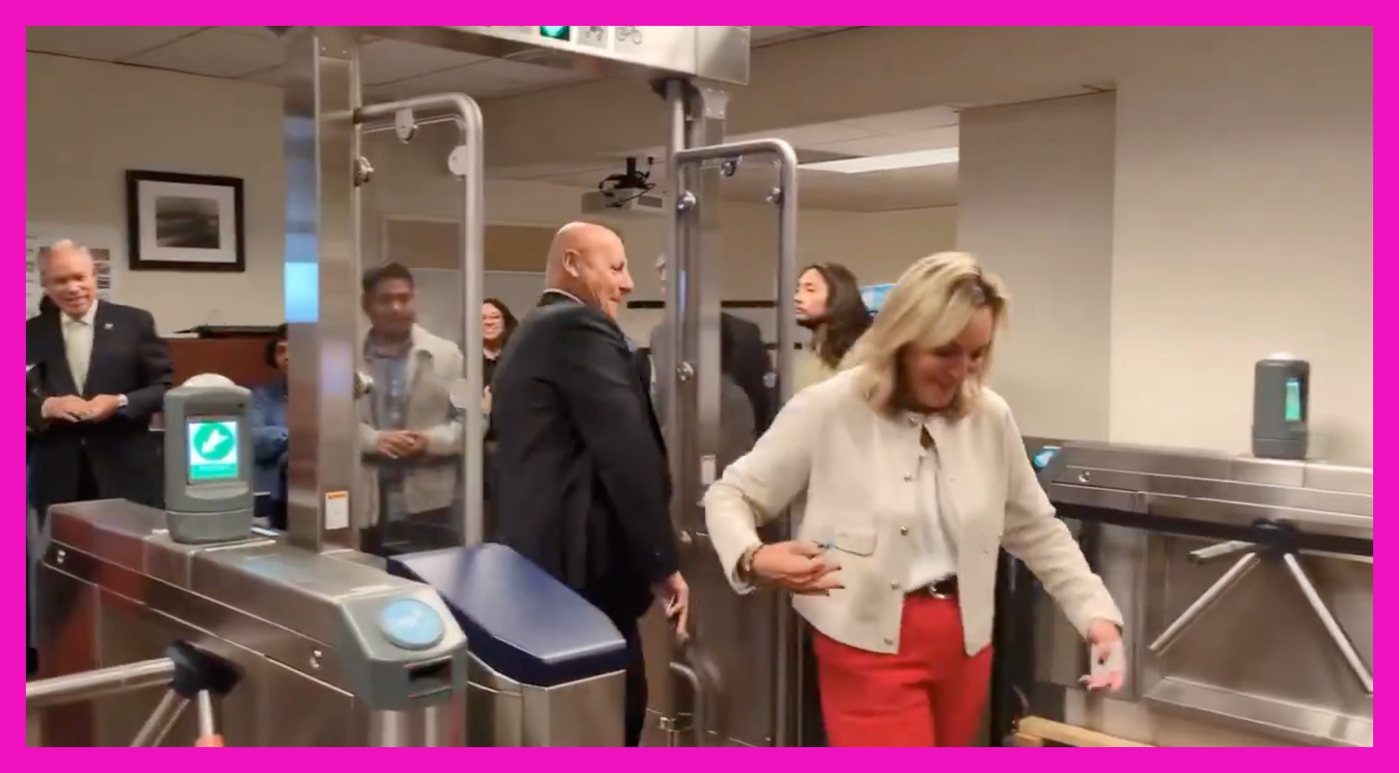 Metro board members walking through test subway turnstiles in what looks like a conference room with Ara Najarian scooting behind Kathryn Barger in what looks like fare evasion