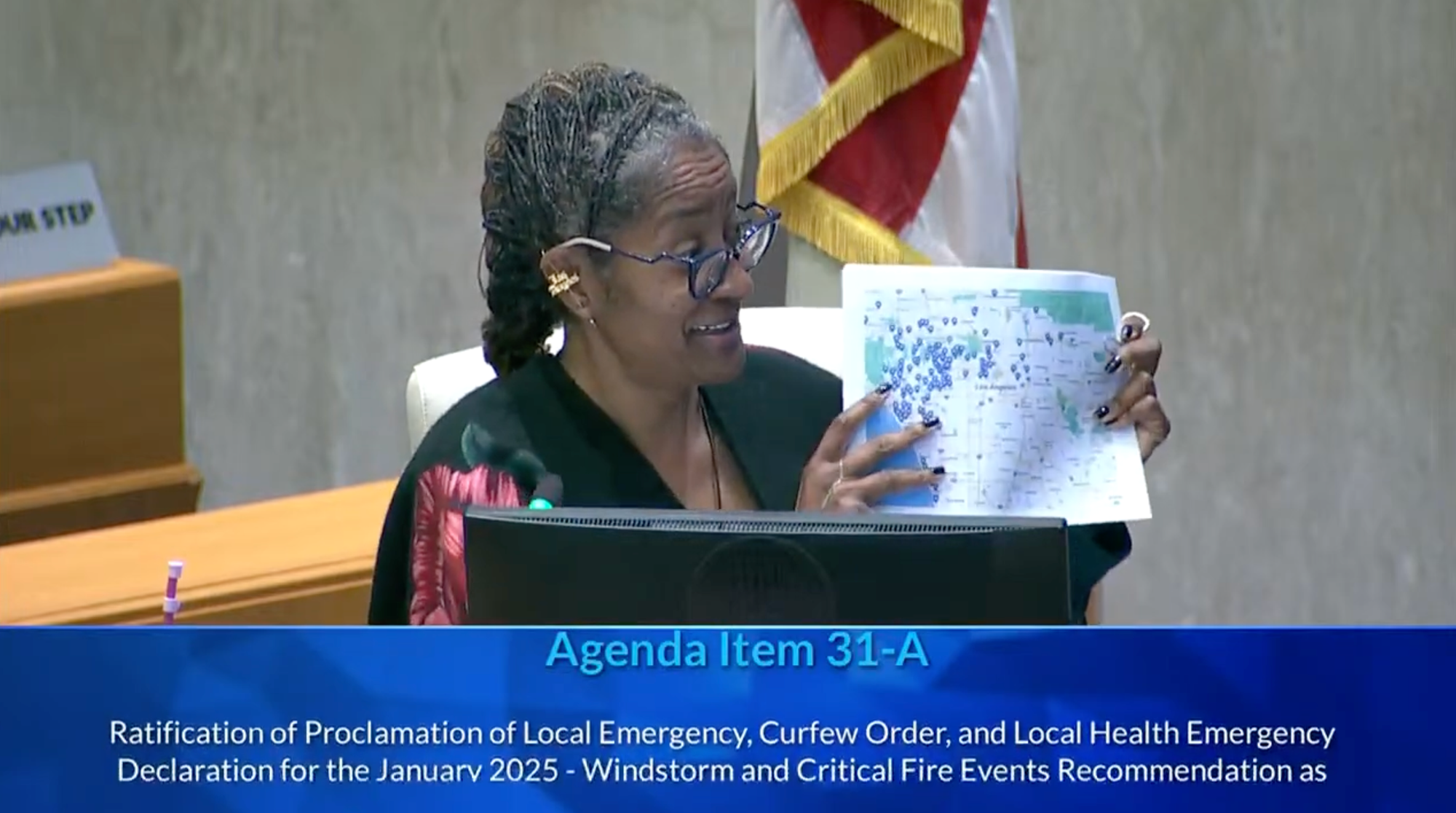 Holly Mitchell, LA County Supervisor, holds up a map of LA rentals at the county'board meeting