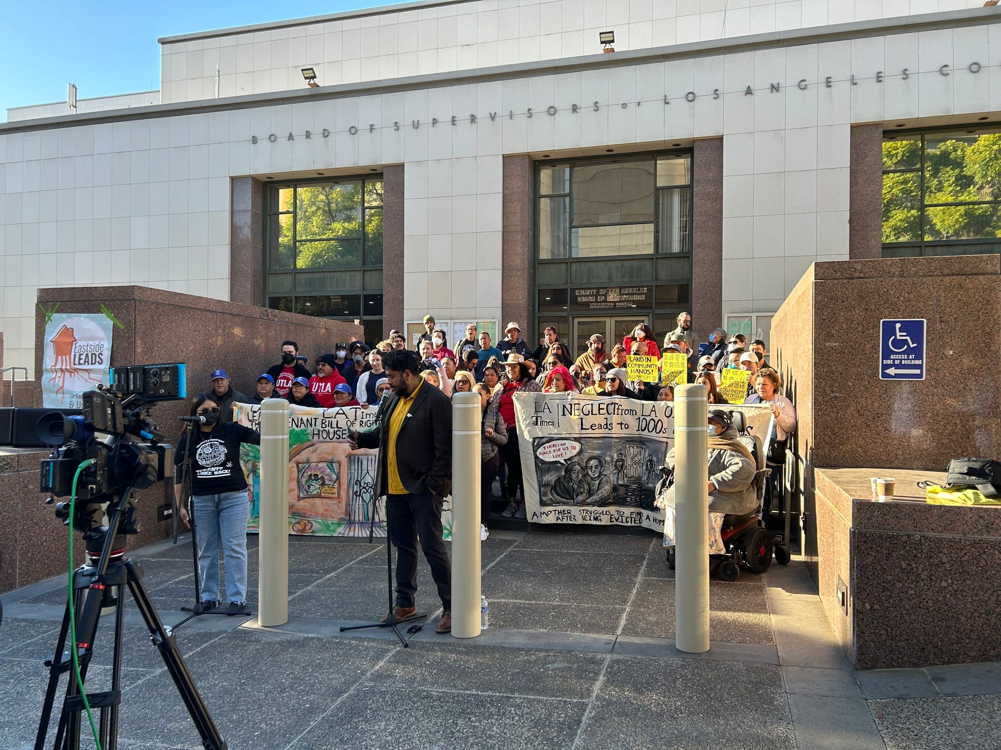 A large rally of tenant organizers outside LA's county administration building holding banners about evictions and tenants rights